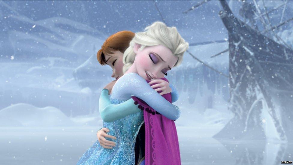 Les deux sœurs, Elsa et Anna, se prennent dans leurs bras à l'extérieur, durant une tempête de neige